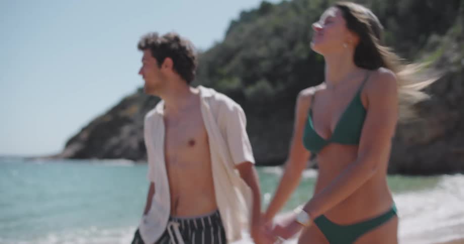 Smiling man and woman walking along the beach