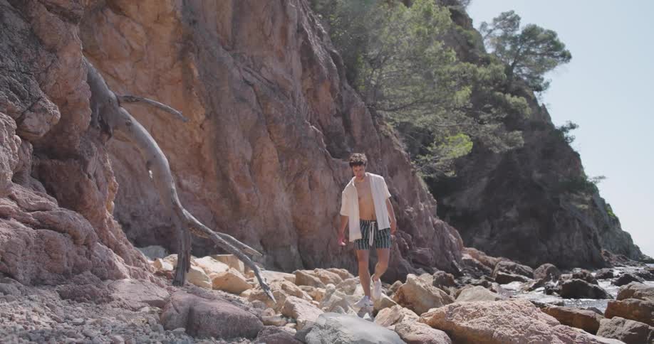Man walking along the rocks in a natural environment by the sea