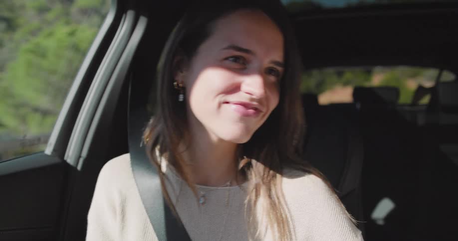 In the passenger seat a woman sways to the rhythm of the music and smiles