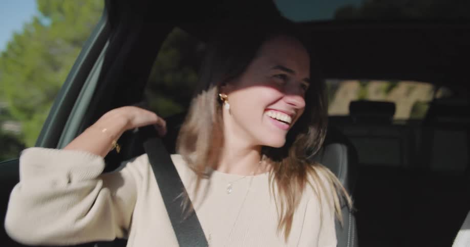 A young happy couple enjoying a road trip sing and dance together