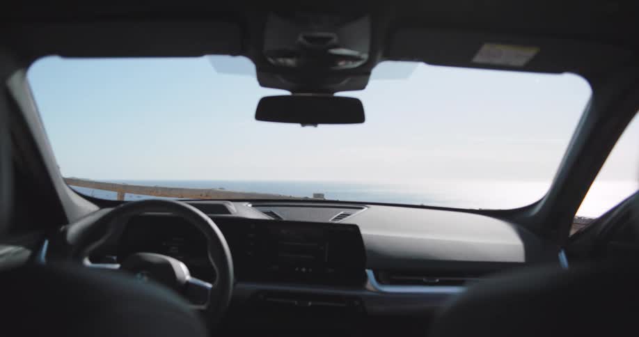 A young couple board a car near the ocean