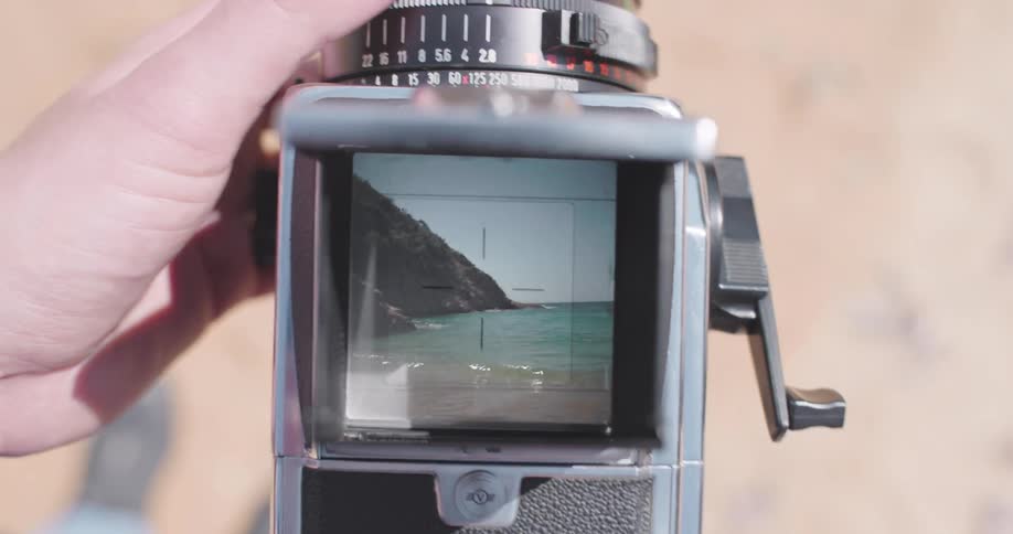 A closeup view of a vintage camera with its viewfinder focused on a landscape scene