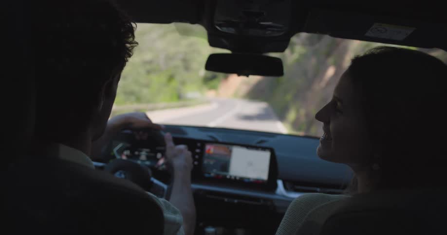 A man and a woman talk while driving in a car