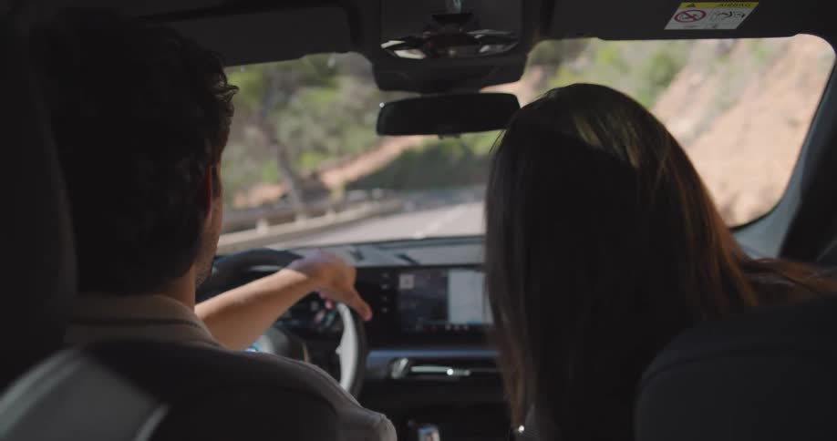 Couple having fun while the husband drives the car in a natural environment