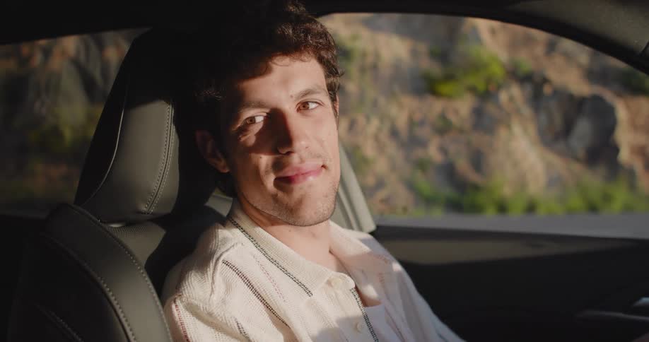 Portrait of a man inside the car looking to the side and smiling