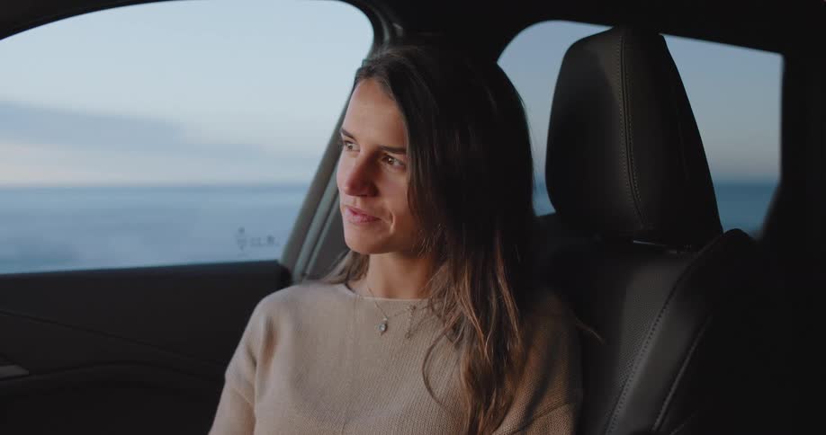 A clip of a lady smiling in a car