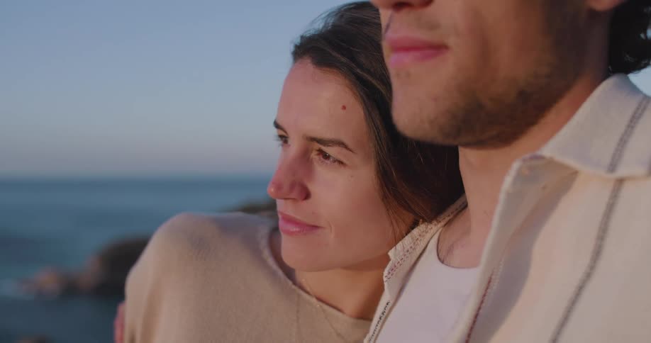 A couple shares a romantic moment on the beach the woman smiles