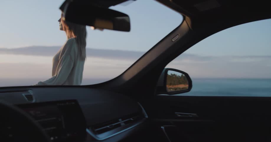 Woman getting out of the car and heading towards a natural panoramic view