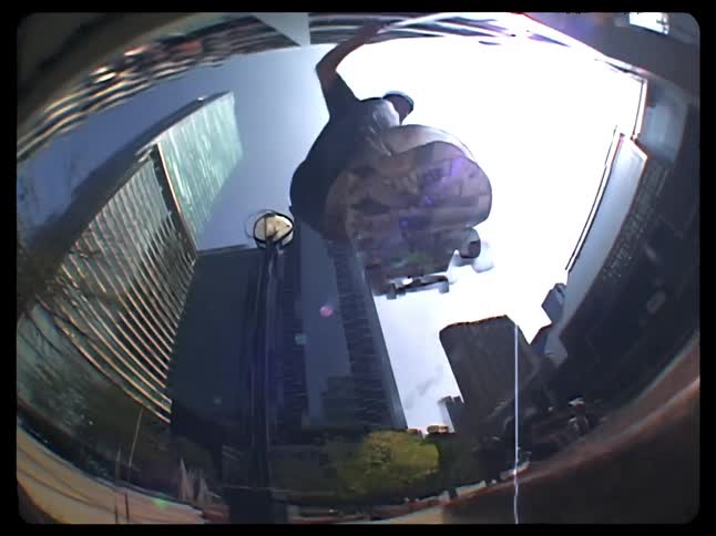 Man doing a trick with his skateboard on a handrail in the city