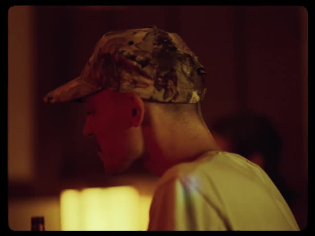 Happy man wearing a cap in a bar drinking beer from a bottle