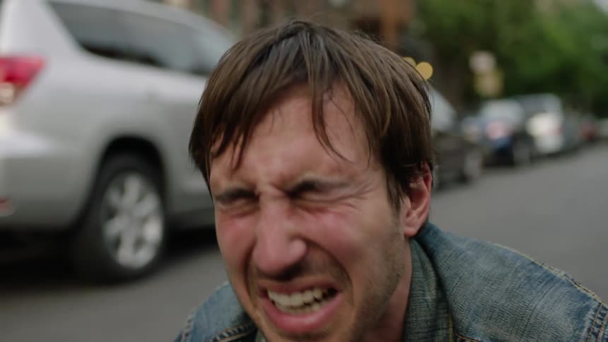 Man crying uncontrollably while knelt down in the middle of a city street