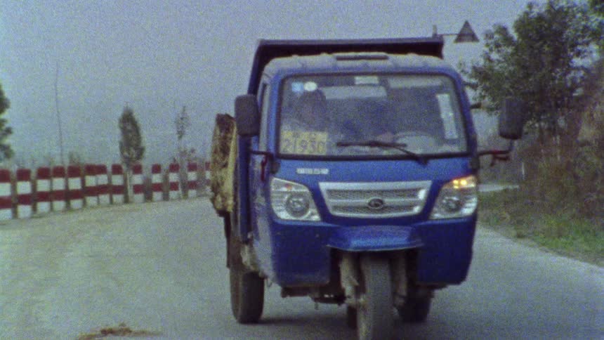 Mini trucks traveling around a curve on a paved street