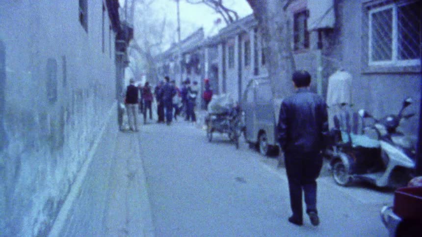 Alley with pedestrians and a group of people and with houses around