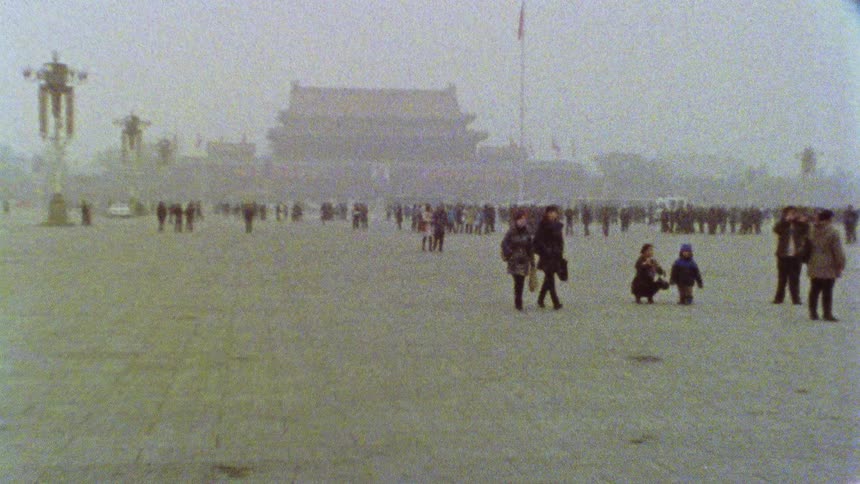 People walking through the iconic Tiananmen Square on a hazy foggy day