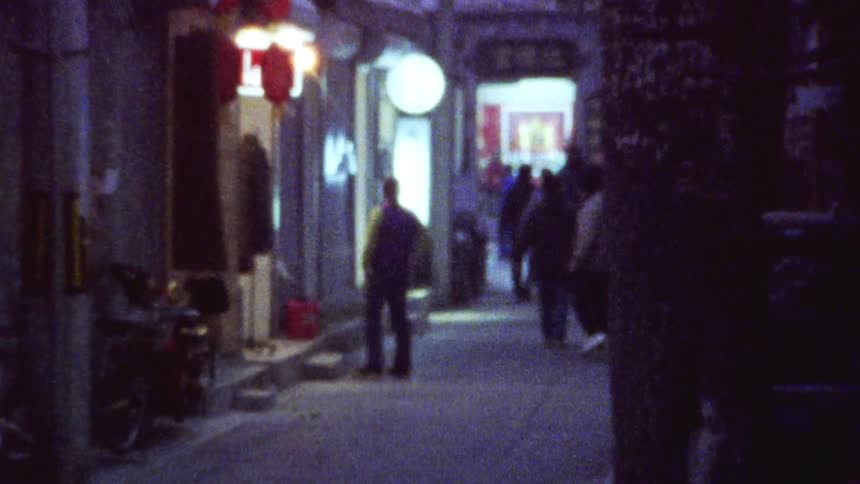 Beijing alleyway at night with houses, shops, pedestrians walking