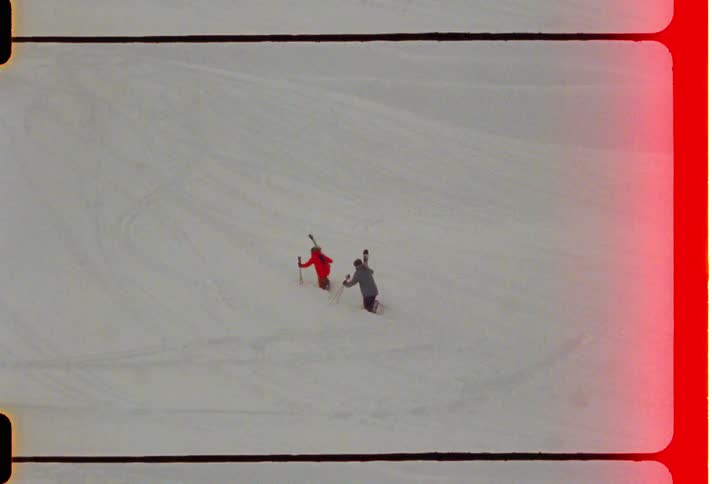 Two people climbing a snowcovered mountain with ski equipment