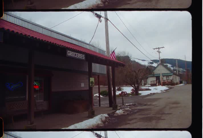 Facade of a closed bar with neon lights around it on a deserted street in a natural environment with snow