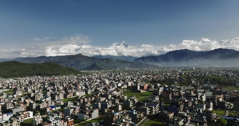 Aerial panorama of an urban city built in a valley with mountains around it