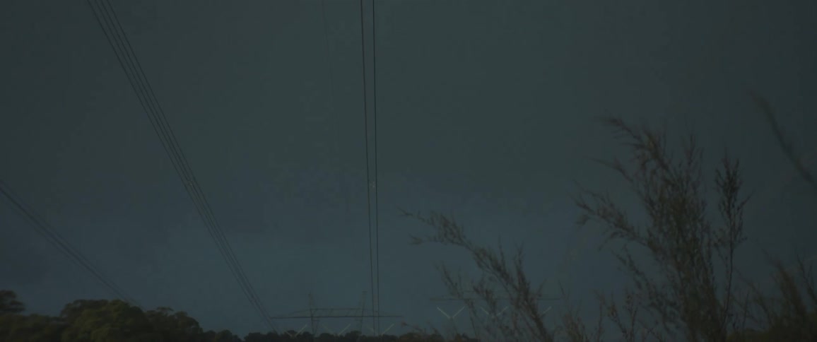 Overhead powerl lines under an overcast sky at dusk