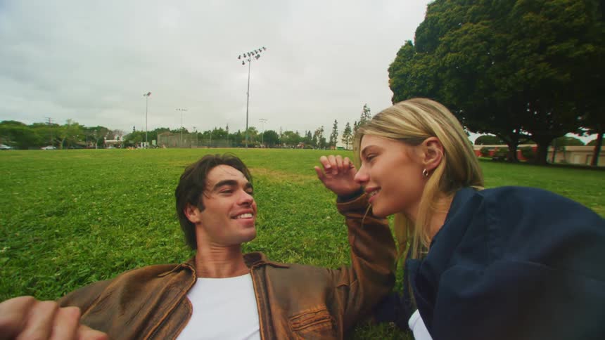 Smiling couple lying on the grass in a park