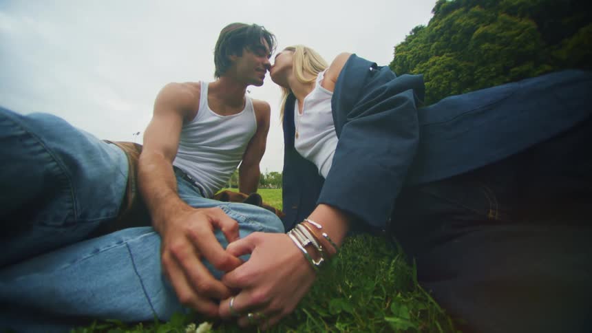 A couple are making out on the grass