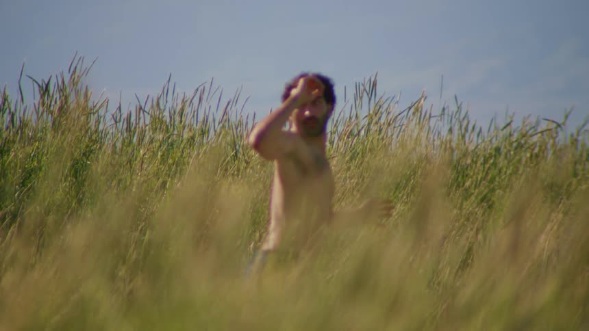Man and a hill in the natural environment with vegetation around him without a shirt dancing