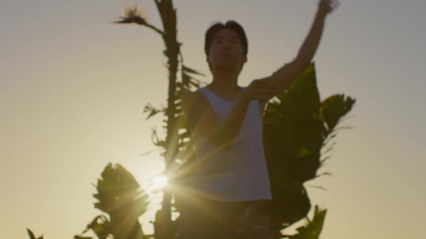 A man performs slow moving exercises outdoors