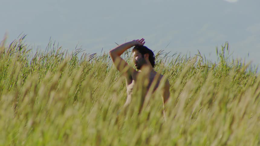 Man without a shirt in the middle of the woods dancing