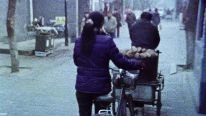 People carrying freshly cooked food on a bicycle caught on vintage film