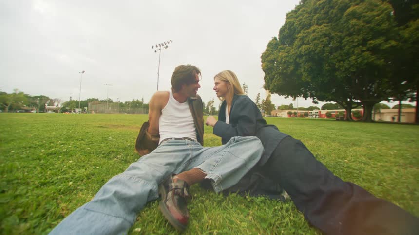 A couple are sitting on the grass in the park
