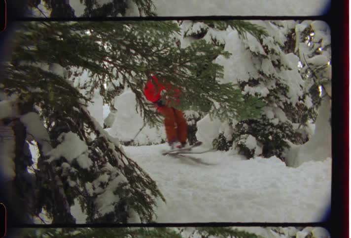 Person skiing in the mountains with snow and conifers around