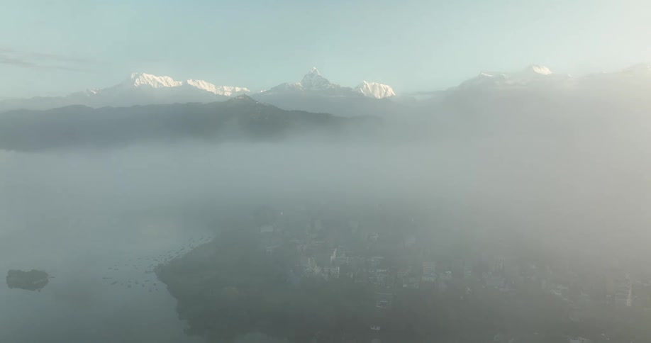 The city sprawls out along the coast with a scenic lake and snowcapped mountains in the distance