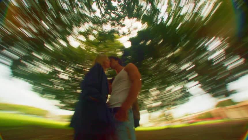 Romantic couple in a park holding each other with trees around them
