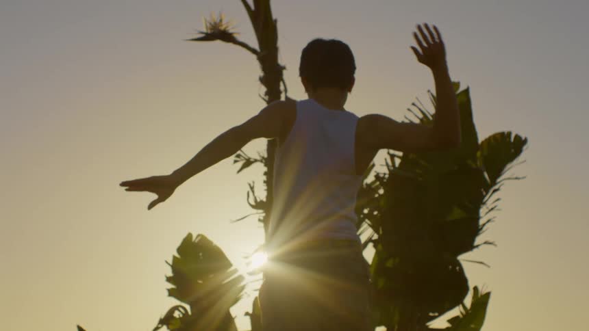 A man is dancing in as the sun rises