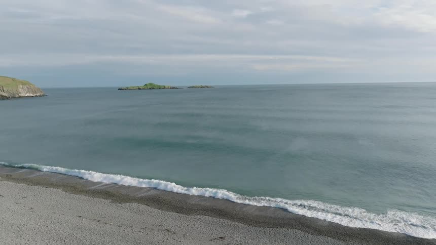 Aerial panorama of a blue sea and the rocky coast with vegetation