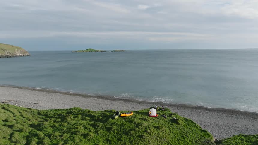 Aerial view of two people camping near the beach in the coast