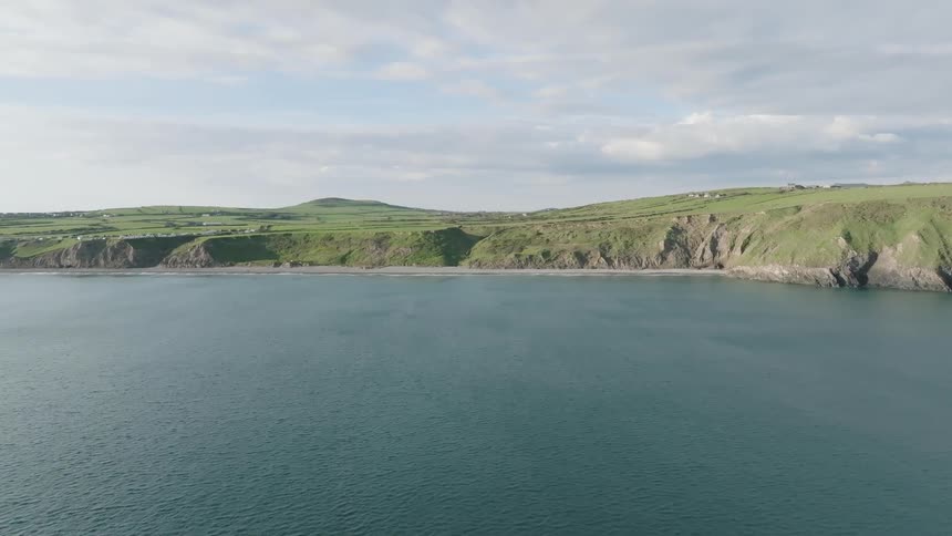 Aerial scenery with blue sea and rolling green fields