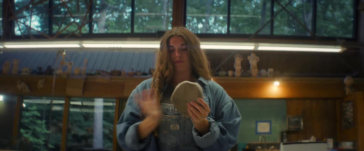 Woman kneading a grayish clay dough with her hands