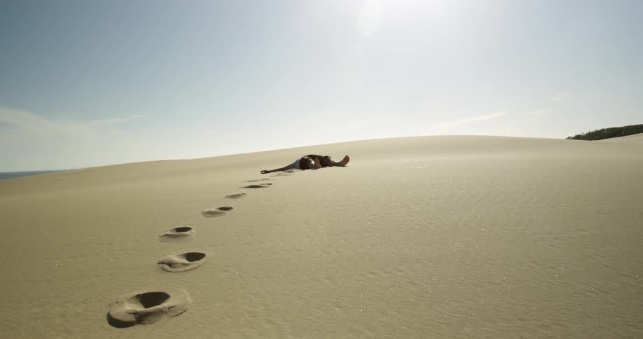 A man lays in the desert sand