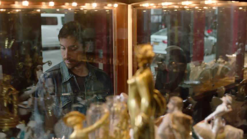A man window shops in front of a store