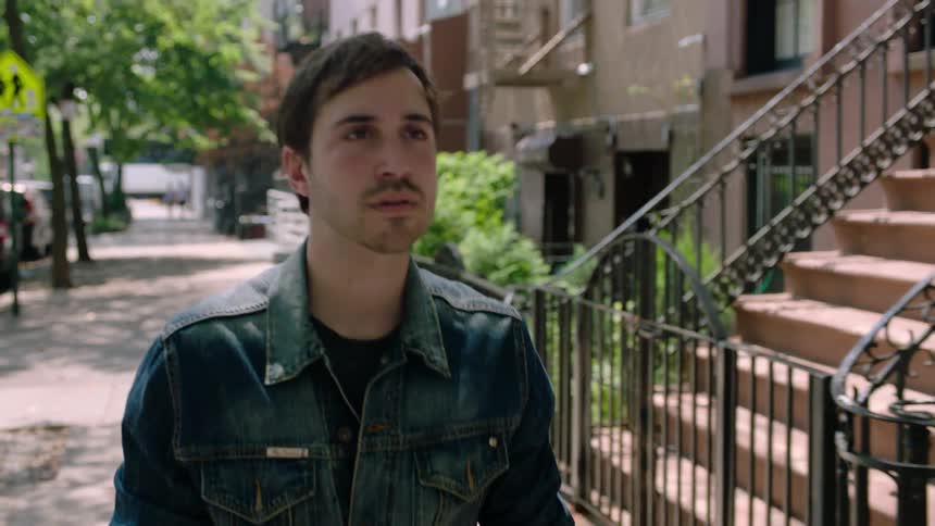 A man looks around while walking down the street