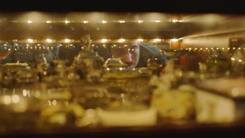 A man is looking at decorative glass in a shop