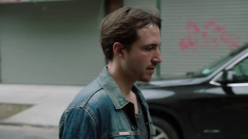 A sweating man walks nervously down a street