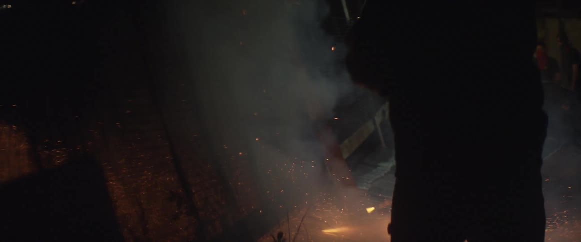 Man standing as fireworks shoot all over night sky