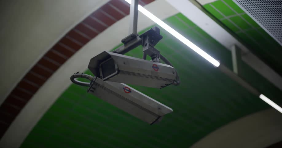Two security cameras are mounted on the ceiling of a retail store