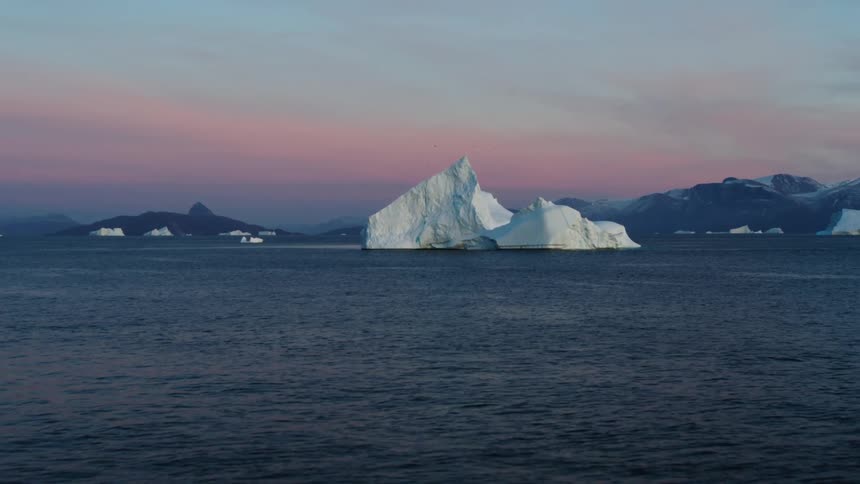 Arctic icebergs in the ocean at dusk