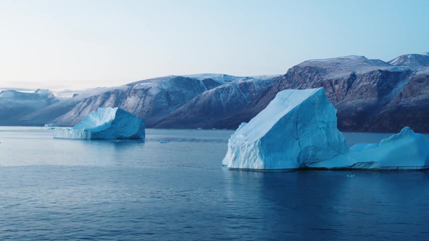Arctic icebergs floating the ocean a mountain landscape in the background