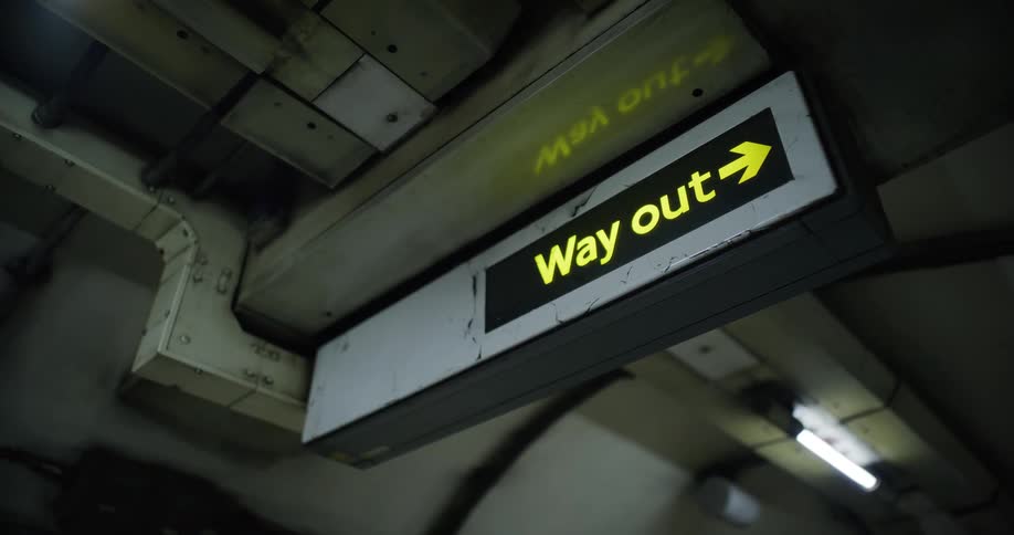 A sign pointing towards the exit in a transport station
