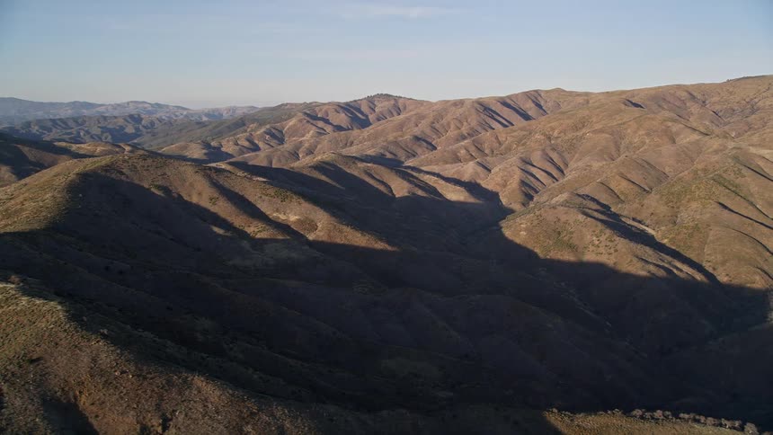 Aerial view of the sun shining on barren mountains