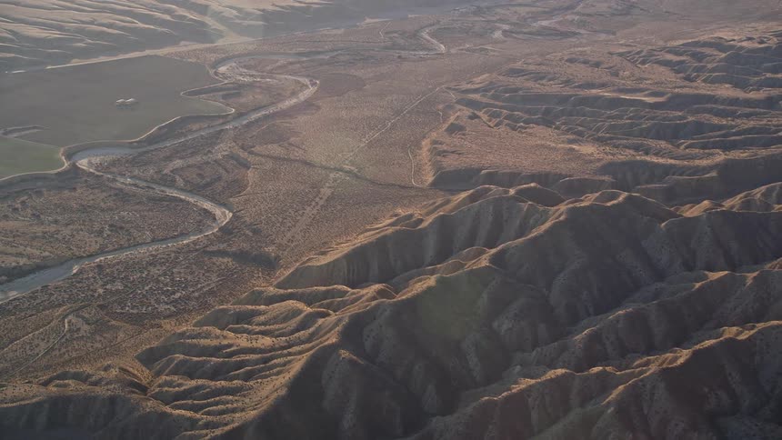A road crossing desert terrain covered in sandy hills
